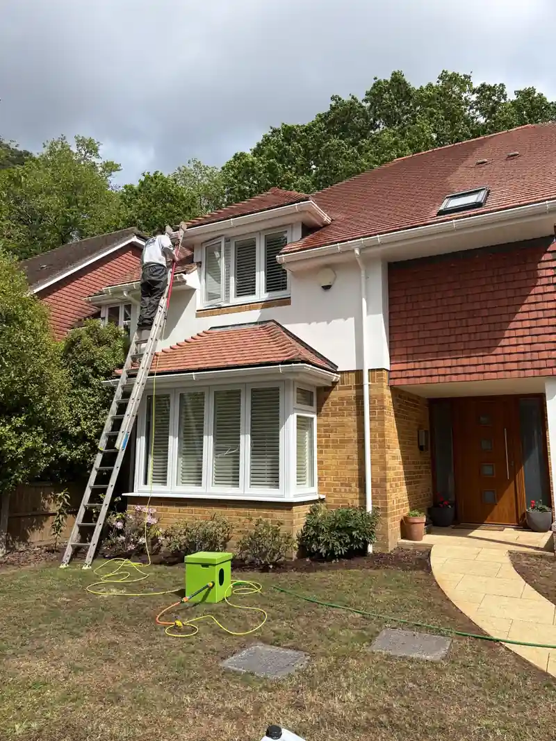 Clearing the gutter of a house from a ladder